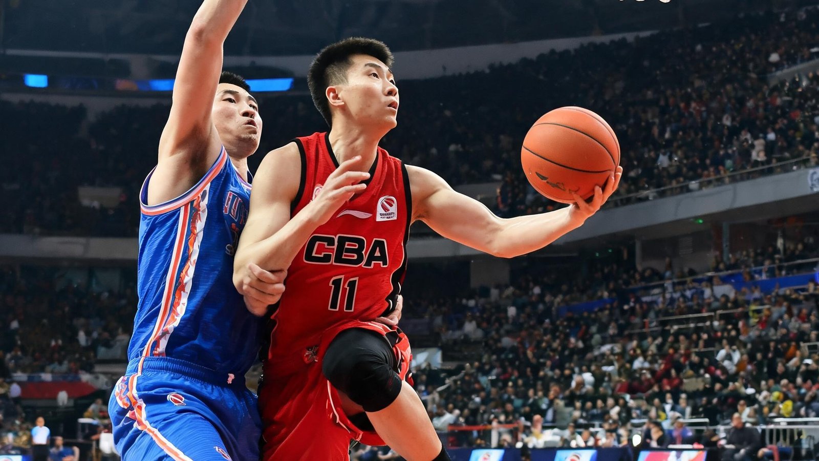 CBA联赛中一名国内球员突破上篮，防守球员紧贴